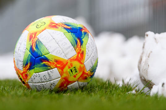 A soccerball next to a pile of snow