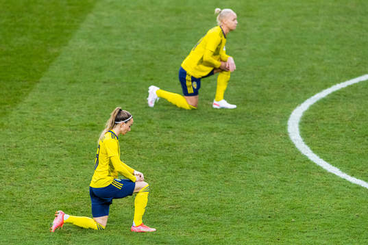 Kosovare Asllani and Caroline Seger of Sweden takes a knee