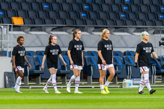 Players of USA enter the pitch wearing t-shirts in support