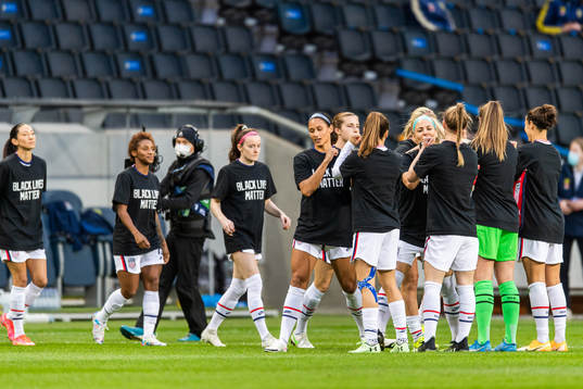 Players of USA enter the pitch wearing t-shirts in support