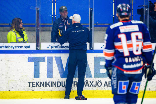 En vaktmästare lagar ett trasigt plexiglas