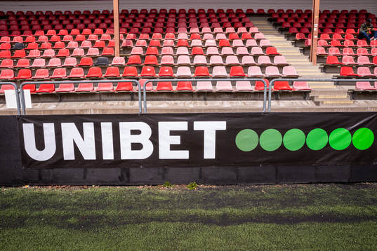 Unibet logotyp nedanför huvudläktaren på Skytteholms IP