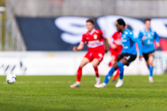 Gräs på plan med spelare i bakgrunden