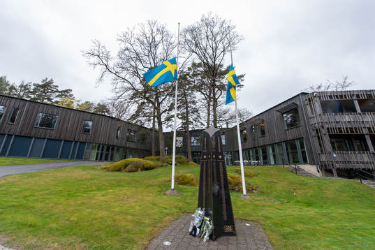 Blommor utanför Kamratgården och flaggorna på halv