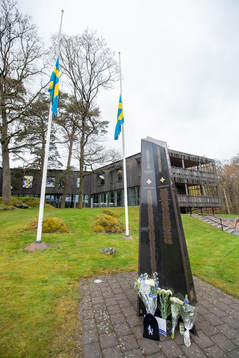 Blommor utanför Kamratgården och flaggorna på halv