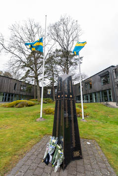 Blommor utanför Kamratgården och flaggorna på halv