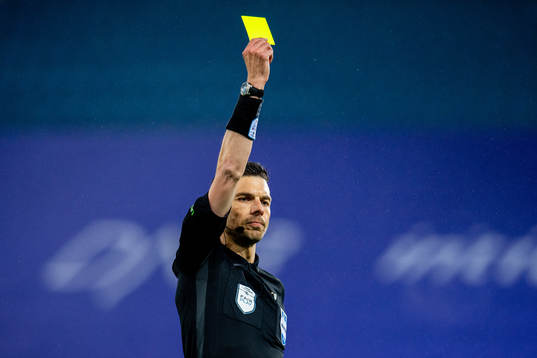 Tore Hansen, referee, hands out a yellow card