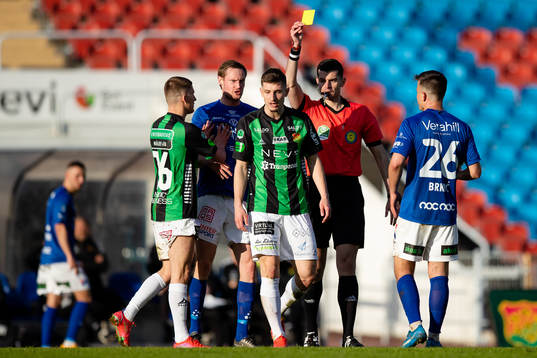 Domare Enzo Vesprini delar ut ett gult kort till GAIS Adnan