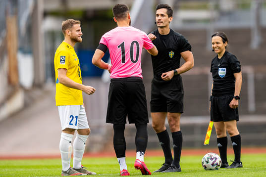 Domare Fikret Buqa hälsar på IFK Malmös Martin Johansson