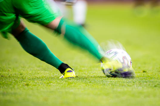 En målvakt sparkar på en fotboll