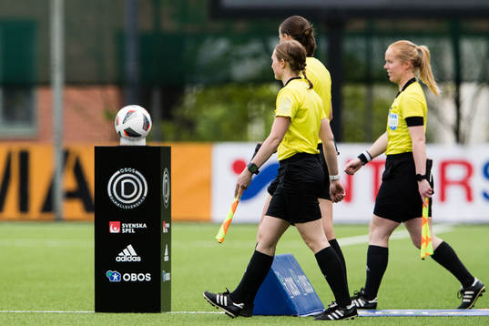 Domarteamet och matchbollen innan fotbollsmatchen i