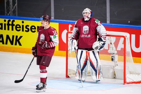 Rihards Marenis and Goalkeeper Matiss Kivlenieks of Latvia