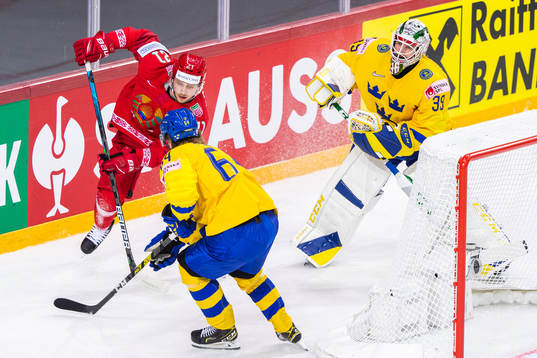 Vladislav Kodola of Belarus competes for the puck with