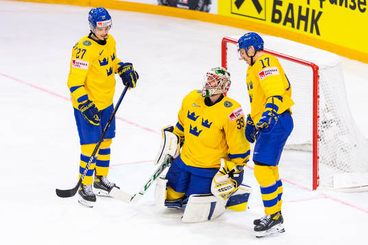 Nils Lundkvist and Pär Lindholm attends to goalkeeper Adam