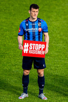 Herolind Shala of Stabæk holds a Stopp Rasismen sign