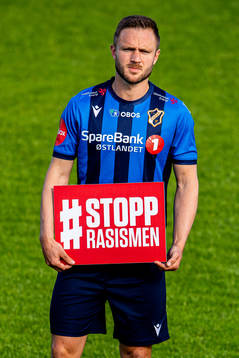 Mats Solheim of Stabæk holds a Stopp Rasismen sign