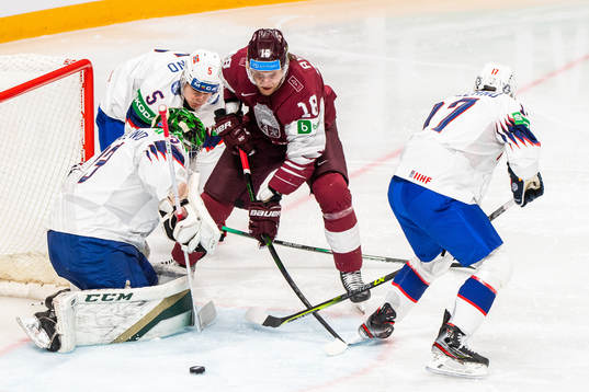 Rodrigo Abols of Latvia competes for the puck with
