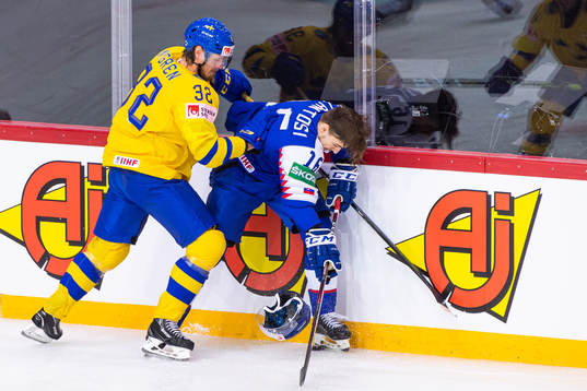 Magnus Nygren of Sweden competes for the puck with Robert