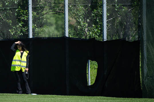 A security guard next a hote in the fence