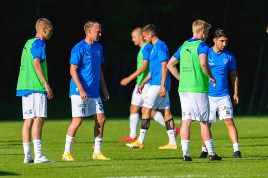 Bergas spelare värmer upp före fotbollsmatchen i division