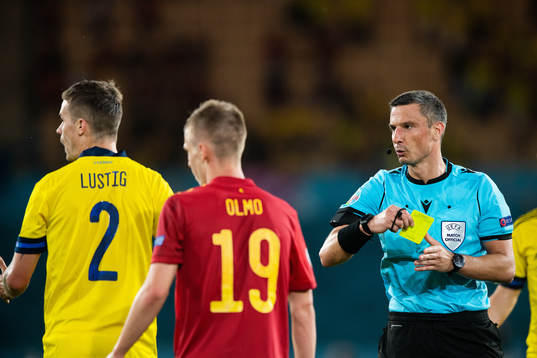 Mikael Lustig of Sweden receives a yellow card from referee