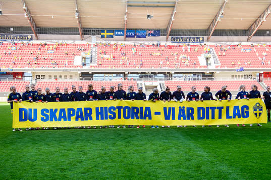 Players of Sweden holding up a banner to celebrate Caroline