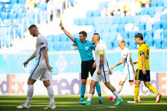 referee Daniel Siebert shows the yellow card to Kristoffer