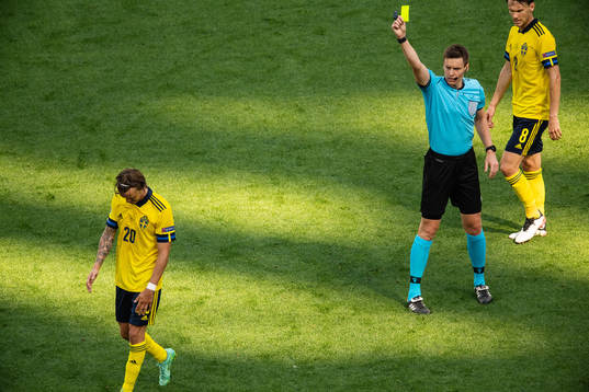 Kristoffer Olsson of Sweden receives a yellow card from