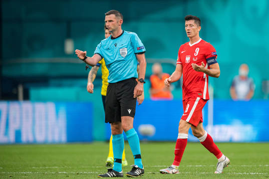 Referee Michael Oliver and Robert Lewandowski of Poland