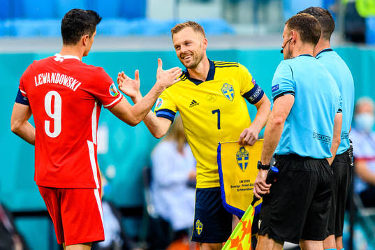 Robert Lewandowski of Poland and Sebastian Larsson of Sweden