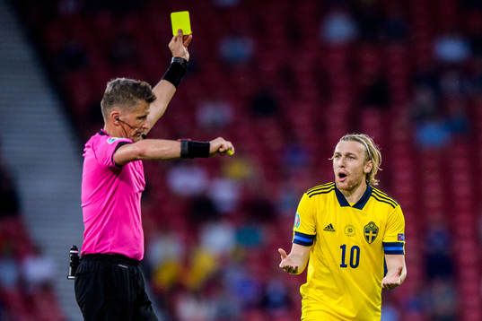 referee Daniele Orsato shows a yellow card to Emil Forsberg