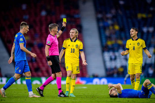 referee Daniele Orsato shows a yellow card to Emil Forsberg