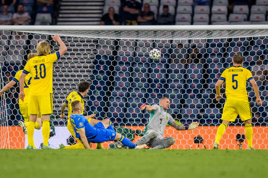 Artem Dovbyk of Ukraine and goalkeeper Robin Olsen of Sweden