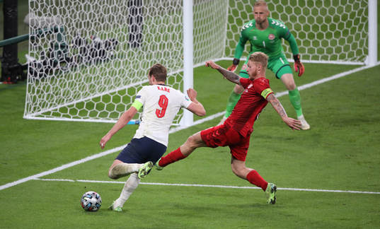 Harry Kane  of England and Simon Kjær of Denmark