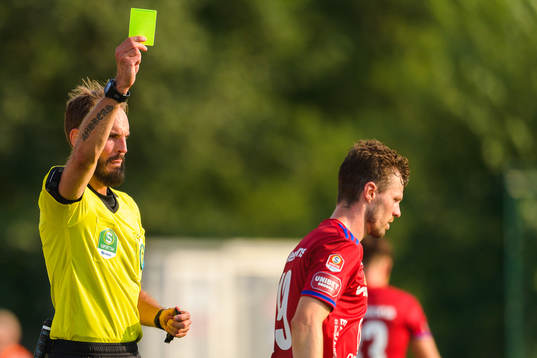 Domare Andreas Dufva Johansson delar ut ett gult kort till