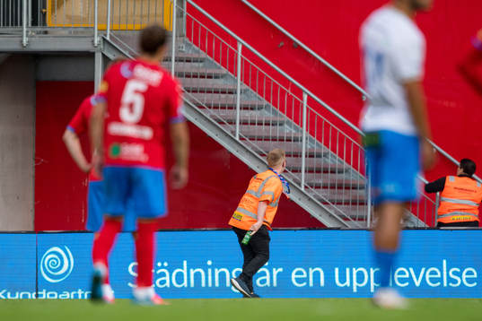 En publikvärd plockar bort en inkastad flaska