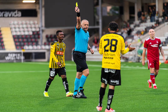 Referee Ádám Farkas gives a yellow card to Samir Maarouf
