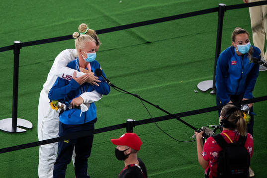 Player of Unites states hugs Caroline Seger of Sweden