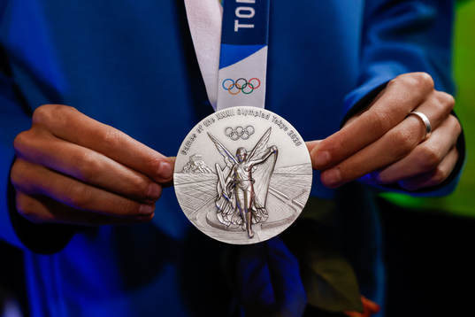 An olympic silver medal is shown at a press meet