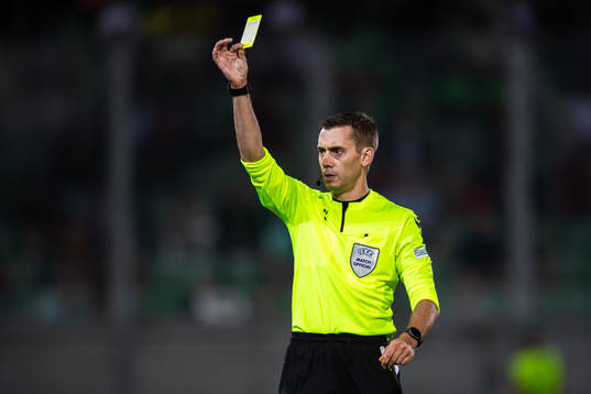 Referee Clement Turpin shows a yellow card