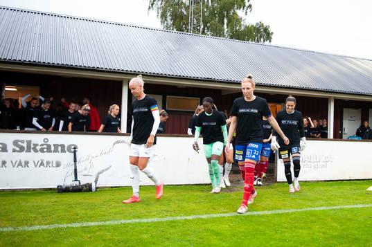 Spelare gör entré till fotbollsmatchen i Damallsvenskan