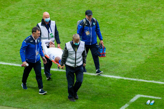Farrukh Ikromov of Uzbekistan is carried off the pitch