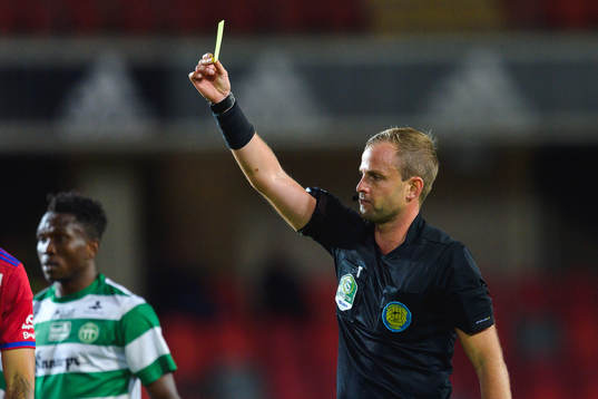 Domare Richard Sundell delar ut ett gult kort