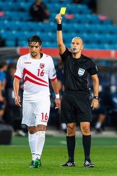 Nikolas Neokleous, referee, gives a yellow card to Aymen