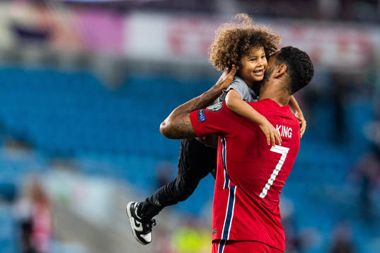 Joshua King of Norway embraces his son