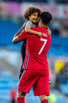 Joshua King of Norway embraces his son