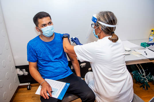 Elna Klemedtson vaccinerar Isaq Rezaie mot covid-19 i