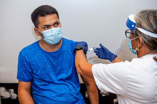 Elna Klemedtson vaccinerar Isaq Rezaie mot covid-19 i