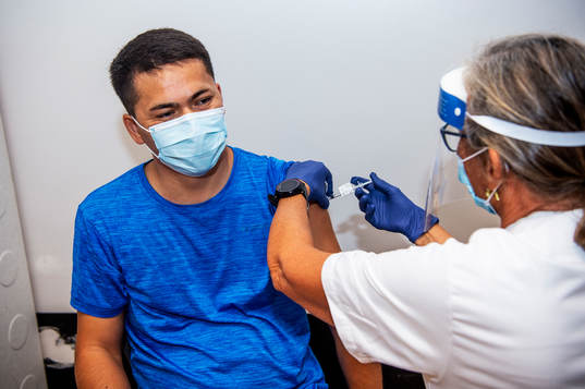 Elna Klemedtson vaccinerar Isaq Rezaie mot covid-19 i