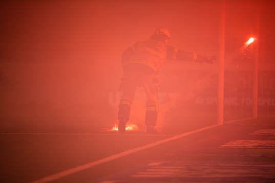 En brandmän slänger undan en bengalisk eld